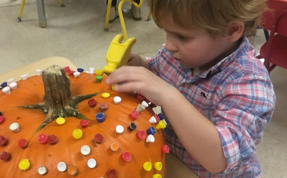 First Congo Preschooler decorating a pumpkin